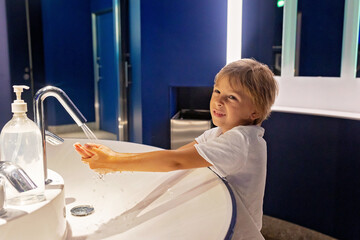 Poster - Little boy, kid washing hands in a public bathroom in Monaco, Monte Carlo