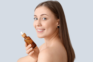 Wall Mural - Beautiful woman with serum on light background, closeup