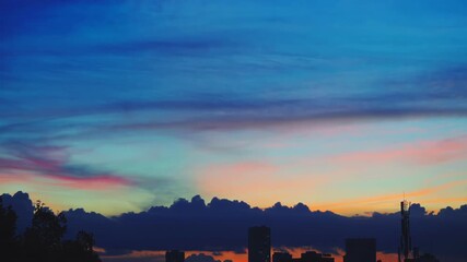 Wall Mural - A breathtaking time-lapse of a vibrant and dramatic sunset. The sky is ablaze with a stunning array of colors, from fiery oranges and deep purples to soft pinks and golden yellows
