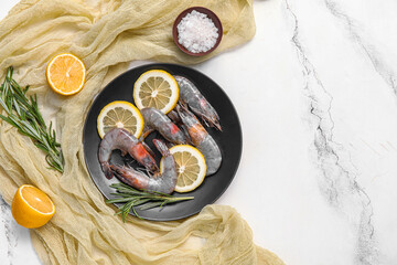 Wall Mural - Plate with fresh raw shrimps, lemon and rosemary on white background