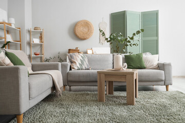 Wall Mural - Interior of living room with sofas, table and green carpet