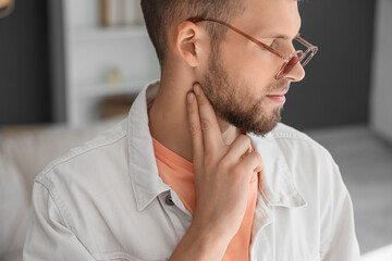 Poster - Young man checking his pulse at home, closeup