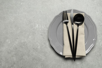 Wall Mural - Stylish cutlery, napkin and plate on grey table, top view. Space for text