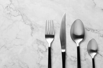 Wall Mural - Stylish cutlery on white marble table, flat lay. Space for text