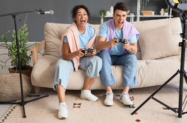 Wall Mural - Couple of bloggers with game pads recording video at home