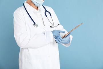 Wall Mural - Doctor with tablet on light blue background, closeup view