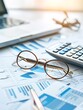 © Achirawee - A detailed financial report with charts and graphs is spread out on a desk, accompanied by a calculator and a pair of reading glasses. This setup illustrates the analytical approach required for