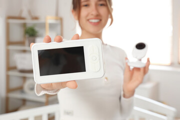 Young woman with baby monitor in bedroom, closeup