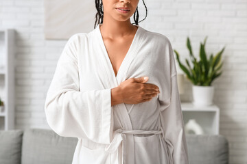 Poster - Young woman in bathrobe checking her breast at home. Cancer awareness concept