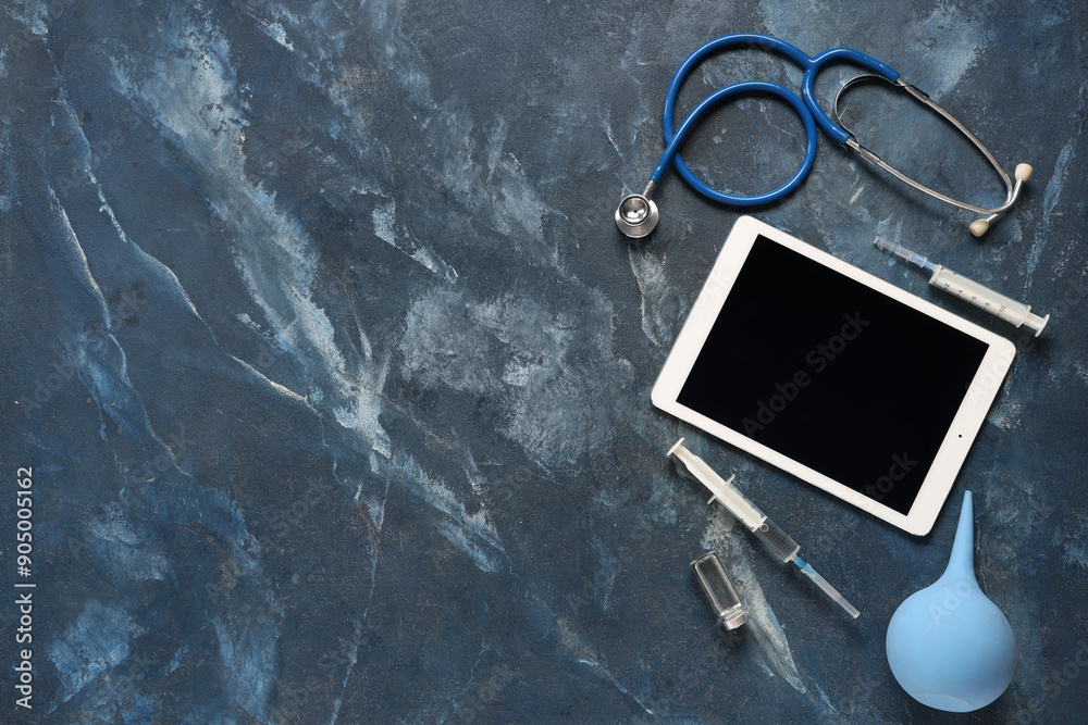 Tablet computer and medical supplies on grunge background. Telemedicine concept