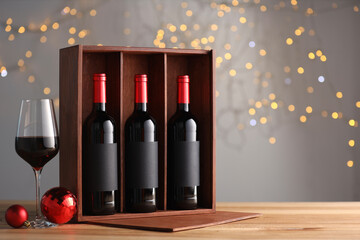 Wall Mural - Wooden gift box with bottles of wine, glasses and red Christmas balls on table, space for text