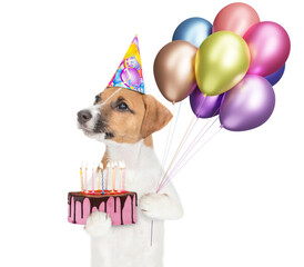 Aufkleber - Happy jack russell terrier puppy wearing party cap holds balloons and birthday cake with candles and looks away on empty space. isolated on white background