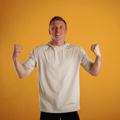 Canvas Print - Winning, happy, hands up. Man is against background in the studio