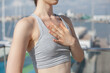 © Dina - woman standing on the pier doing yoga meditation, with hand on heart, doing breath practice on sunny day