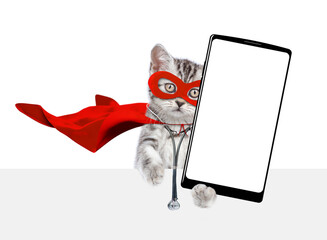 Poster - Cute kitten wearing like a doctor with superhero cape and with stethoscope on his neck shows big smartphone with white blank screen in it paw above empty banner. Isolated on white background