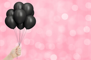 Aufkleber - Female hand holds bunch of black balloons on blurred pink background. Empty space for text