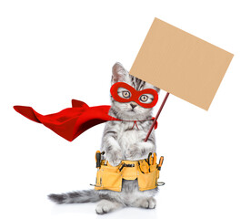 Poster - Cute kitten wearing red superhero costume and tool belt standing on hind legs and showing blank placard. Isolated on white background