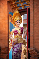 Wall Mural - a beautiful young girl wearing traditional Balinese clothing called payas Agung, elegant and graceful with dominant gold decorations