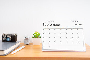 Desktop Calendar for September 2024 year and vintage camera with diary for Planner to plan timetable.