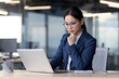 © Liubomir - Businesswoman concentrating on computer work while sitting at desk in modern office. Wearing glasses. Office environment, open workspace. Ideal for business, corporate, and professional concepts.