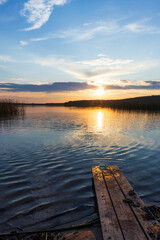 Wall Mural - vertical landscape photo with colorful sunset clouds over still lake