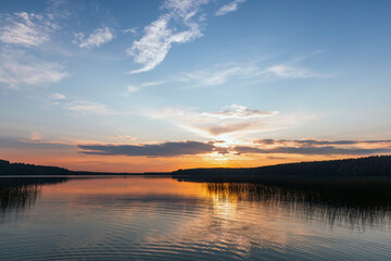 Wall Mural - dramatic sunset landscape with colorful clouds over still lake