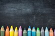 © Денис Никифоров - Colorful Wax Crayons Lined Up on Blackboard Surface with Room for Text