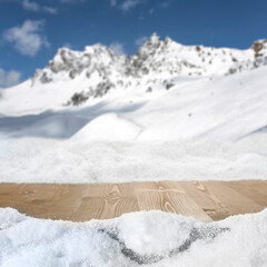Wall Mural - wooden table with copy space for products and snow covered mountains winter background