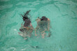 © Milou Dirks - abstract portrait of boy and girl swimming underwater in the blue green swimming pool
