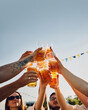 © master1305 - Group of people, friends gathering on picnic, raising glasses with beer, clinking under blue sunny clear sky. Traditional festival. Concept of summer, leisure, friendship, meeting, fun, relaxation