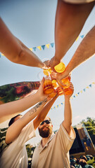 Wall Mural - Summer celebration, friends clink beer glasses under a bright blue sky. Young positive people, men and women meeting outdoors on festival. Concept of summer, leisure, friendship, meeting, relaxation