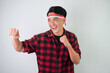 © Rizky - Energetic young asian man wearing Indonesian flag headband, smiling expression, hands raised with clenched fist gesture, isolated over white background. Concept for Indonesian Independence Day.