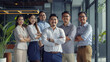 © VK Studio - Energetic, diverse business professionals stand confidently together, representing teamwork and corporate success in a bright office.