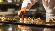 © Felippe Lopes - A chef carefully places a piece of sushi on a plate.
