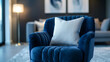 © SashaMagic - Close-up of blue armchair with cushion in modern living room.