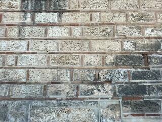 Brick wall texture, closeup of an old exterior surface as a background. Building face wall, convex joint line between dissimilar faded bricks brings character and dimensionality to vintage masonry.