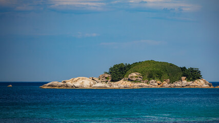 A Landscape of small rocky island on the sea with blue sky