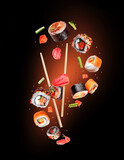 Fototapeta  - Levitation of various fresh sushi rolls with salmon pieces in the air on a black background