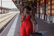 © Anna Berkut/Stocksy - woman tourist using phone on railway station, travel by train