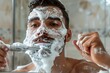 © Divyesh - Man with face covered with shaving foam holding safety razor, removing facial hair while looking at mirror in bathroom, selective focus, Generative AI