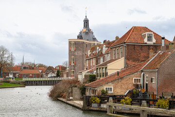 Canal houses with a medieval city gate in the historic city of Enkhuizen.