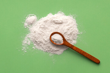 Wall Mural - Baking soda powder in spoon - Healthy food. Green background