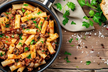 Wall Mural - A delicious top view of pasta with meat and mushrooms in tomato sauce in a pan