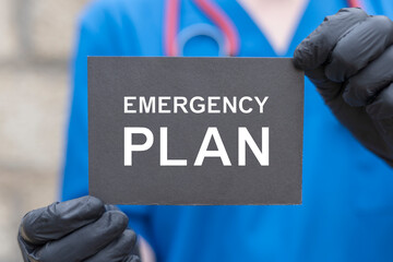 Wall Mural - Doctor holding black card with inscription: EMERGENCY PLAN. Medical concept of emergency preparedness plan.