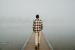 © ADDICTIVE STOCK - Man walking on foggy pier in tranquil nature scene