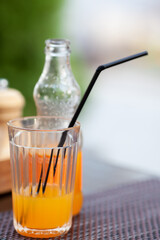 Orange soda in a transparent glass with a straw
