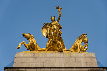 New York, NY, USA - August 2, 2023:  Maine monument golden statue top frontal closeup on SW corner Central Park under blue cloudscape