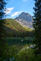 Wall Mural - Incredibly beautiful transparent, emerald calm lake with reflection of rocky mountain on the Black Prince Cirque Trail. Majestic Canadian mountains with snow on sunny summer day in Alberta, Kananaskis