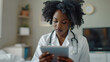 © Andres Mejia - Focused black doctor using digital tablet in hospital room