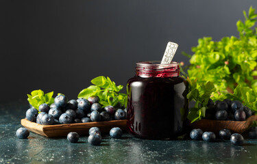 Wall Mural - Blueberry jam and fresh berries with leaves.